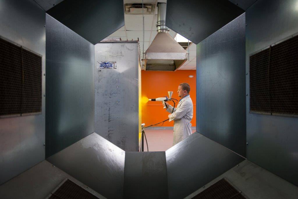 Employee spraying powder at new development lab
